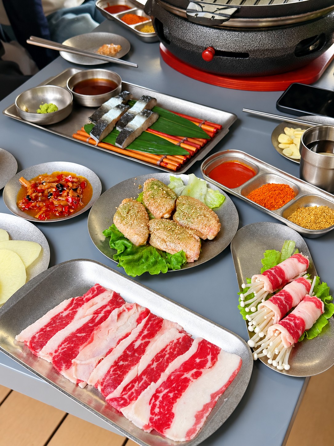 餐桌上的肉片、卷类、配菜与烤盘